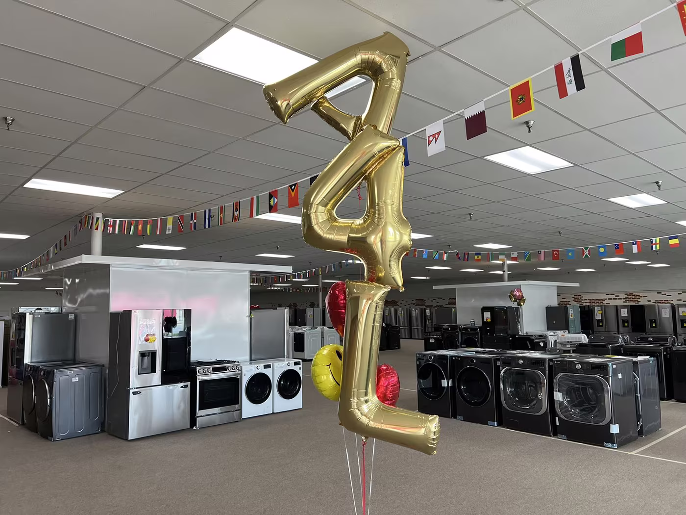 Gold "A4L" balloons over a showroom full of appliances
